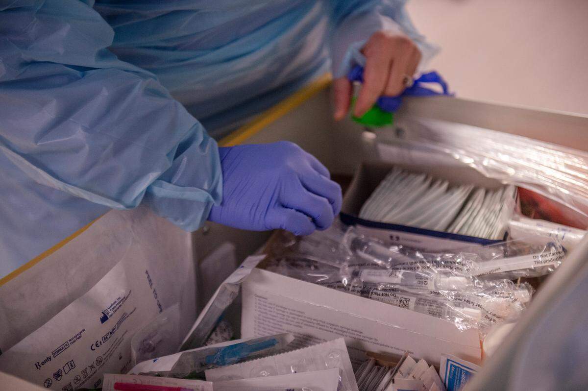 A nurse selects tools before entering a COVID-19 patient’s room in the ICU at Memorial Hospital in Gulfport on Wednesday, Aug. 11, 2021.