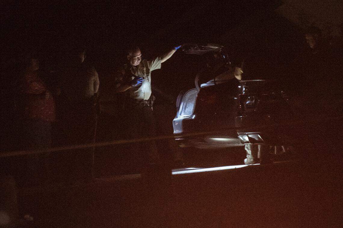 Police officers inspect cars in the driveway of a home on Oakview Circle in Latimer on Thursday, April 7, 2022 after a fatal shooting.