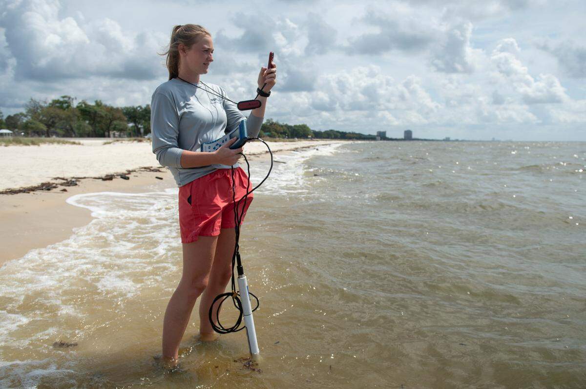 Jennifer Ahlbrand, an environmental natural resource specialist with the Mississippi Department of Environmental Quality, collects data on things like water and air temperature, water salinity and water pH, as well as a water sample from a beach in Gulfport on Wednesday, April 30, 2025.