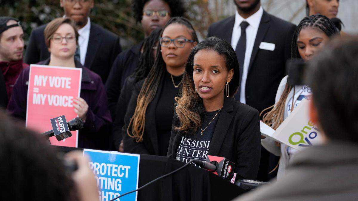 Harya Tarekegn with the Mississippi Center for Justice, center, joins members of other voting rights groups at a news conference in Jackson, Miss., on Thursday, Dec. 7, 2023. (AP Photo/Rogelio V. Solis)