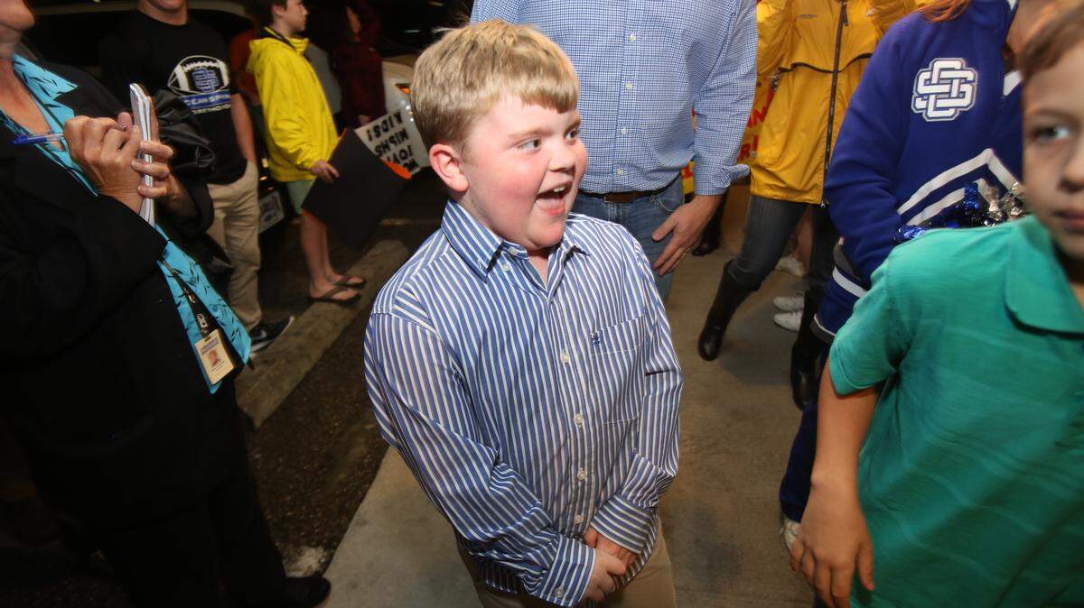 AMANDA McCOY/SUN HERALD 
 Cooper Clower, 9, arrives at Woody's Roadside where friends and family surprised him on Sunday. Clower, who has Duchenne Muscular Dystrophy, learned that he gets his wish from the Make-A-Wish Foundation.