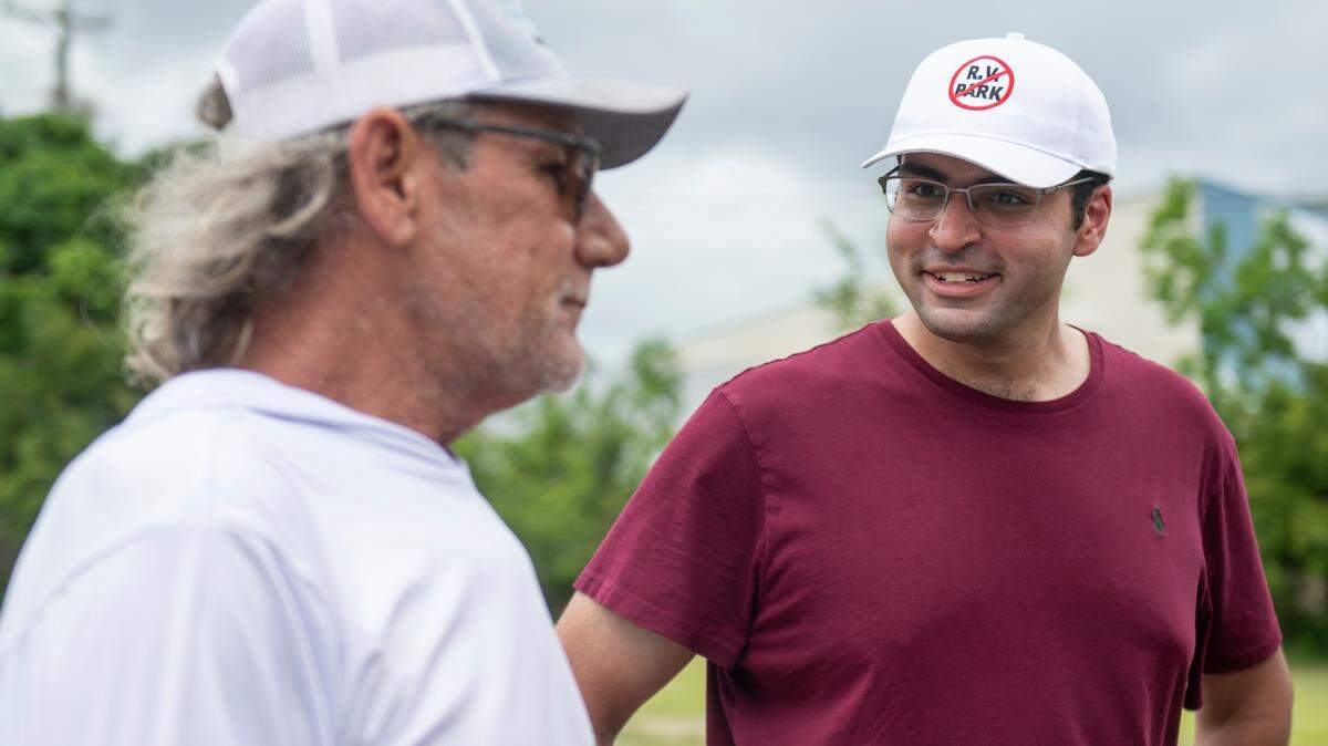 Eamon Mohiuddin, right, who filed a lawsuit in attempt to stop the development of an RV park in Jackson County, shares his concerns with Ross Broussard at a tent Mohiuddin set up to give out signs on Beachview Drive on Thursday, May 2, 2024.