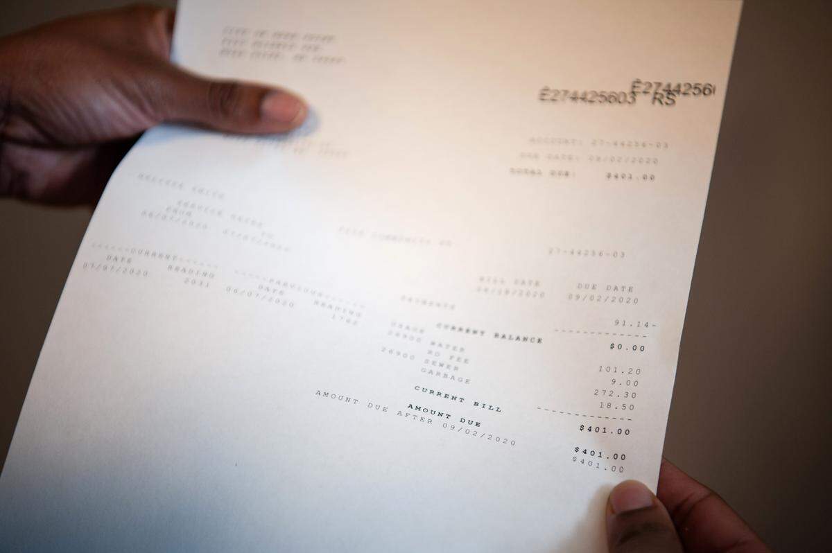 Utilities clerk Melisia Smith exhibits an overcharged water bill her grandmother received at City Hall in Moss Point on Dec. 14, 2023.