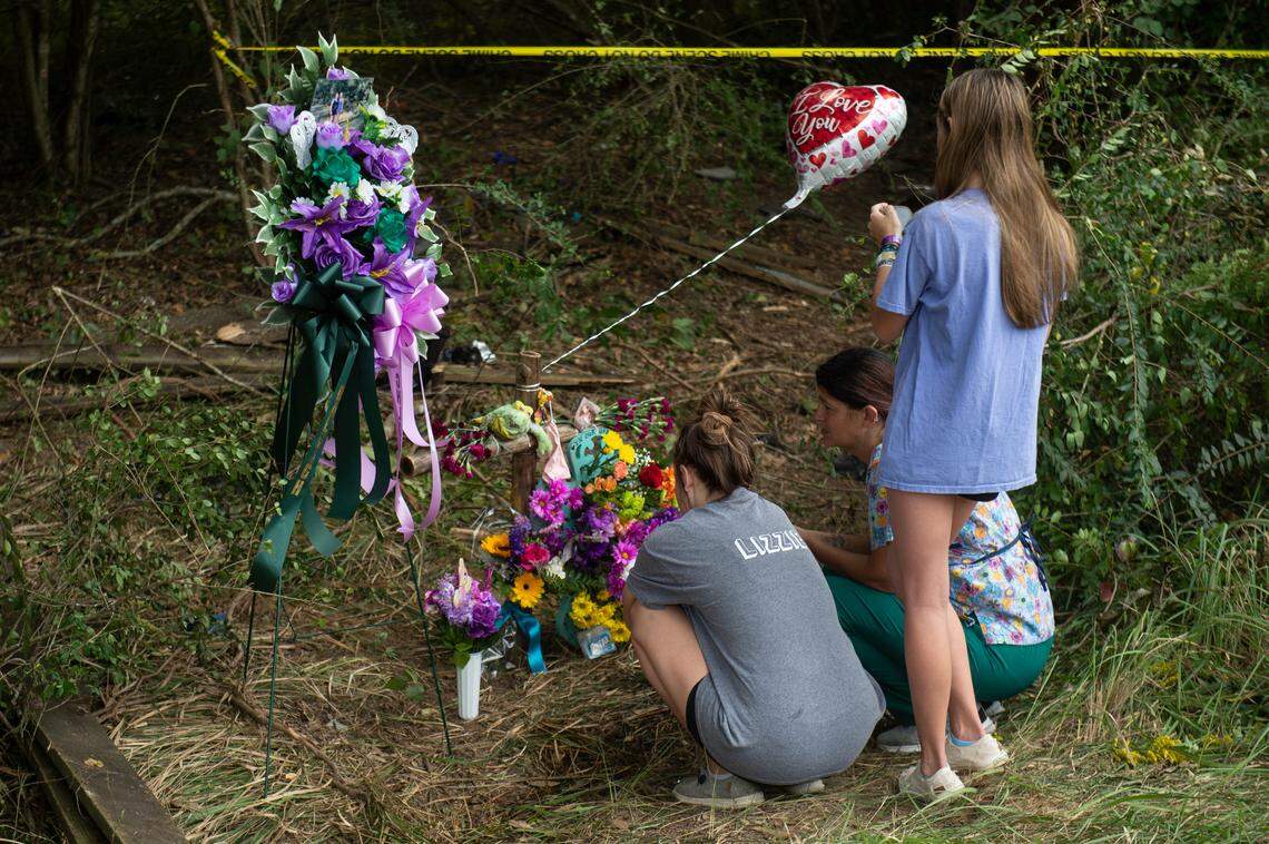 Friends and family of Baleigh Bowlin and Chloe Taylor gather around a memorial for the girls at the site of a fatal car accident that claimed the lives of both girls off of Highway 613 in Hurley on Monday, Oct. 17, 2022.