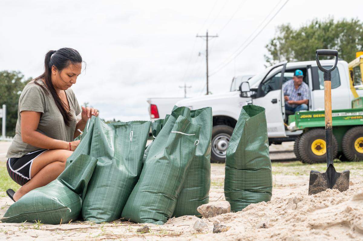 Deisi Barreto ties sandbags in Gulfport in preparation for Hurricane Sally on Monday, Sept. 14, 2020.