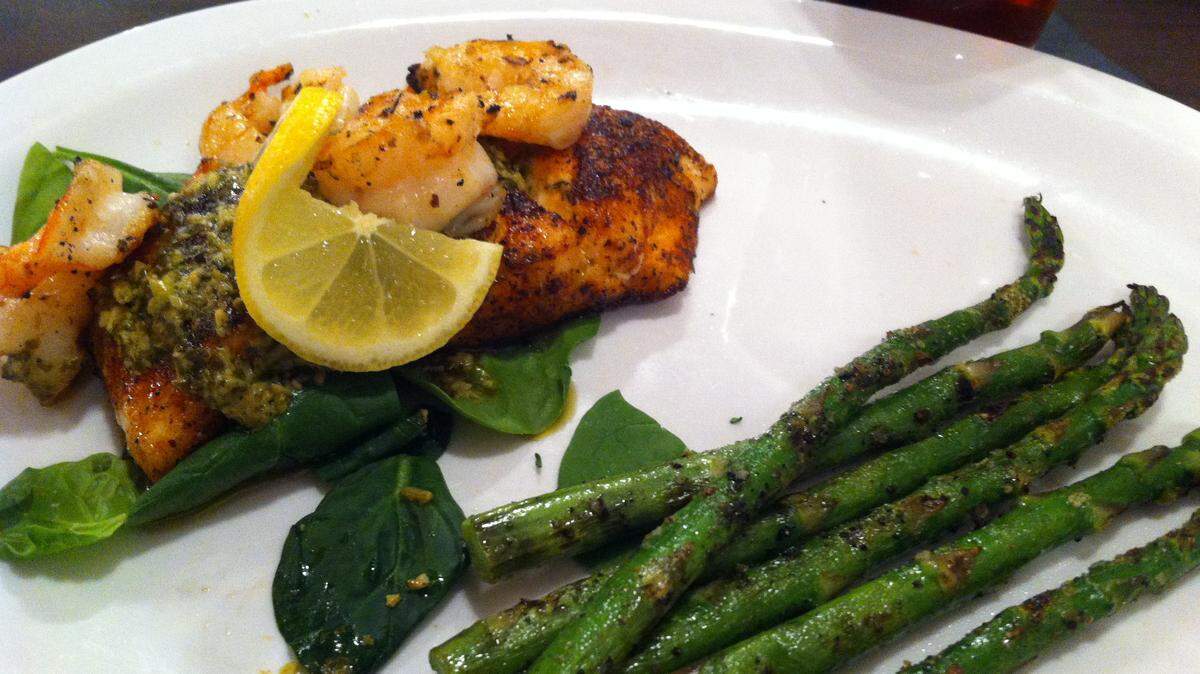 TAMMY SMITH/SUN HERALDBlackened salmon is topped with grilled shrimp and a lemon pesto sauce and served with grilled asparagus for a lunch special at Old Cuevas Bistro in Bay St. Louis.