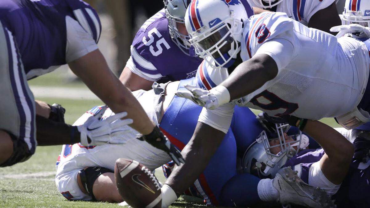 Kansas State offensive lineman Matt Kleinsorge, left, and Louisiana Tech defensive tackle Vernon Butler (9) dive for a ball fumbled by Kansas State running back Justin Silmon during the first half of an NCAA college football game in Manhattan, Kan., Saturday, Sept. 19, 2015. Butler recovered the ball on the play. (AP Photo/Orlin Wagner)