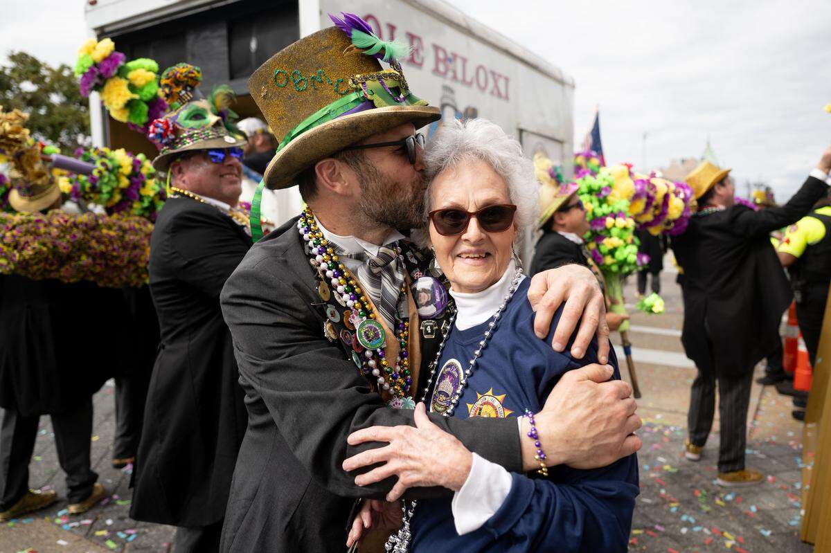 A member of the Ole Biloxi Marching Club embraces a crowd member.
