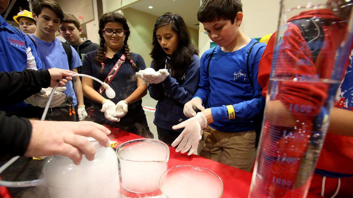 AMANDA McCOY/SUN HERALDStudents crowd around a Mississippi Power booth to see an experiment with dry ice at the Pathways2Possibilities career expo on Wednesday at the Coast Convention Center in Biloxi. The two-day event offers eighth-graders from the six lower counties in Mississippi a chance to explore various potential career paths ranging from finance and human services to aerospace and marine science.