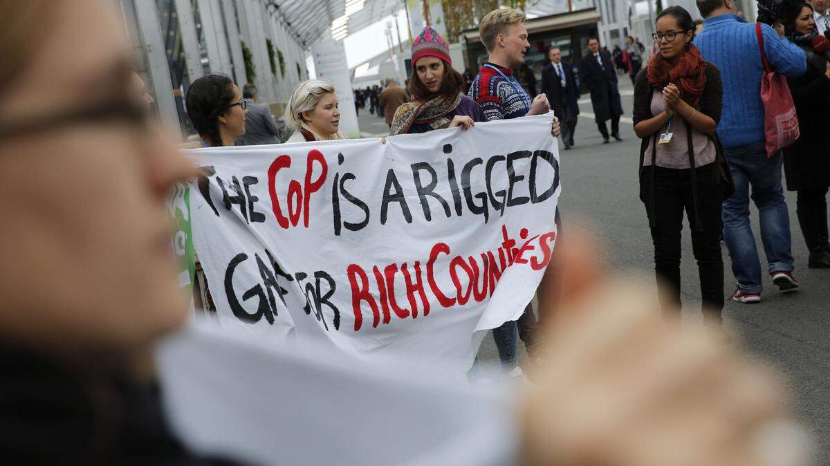 Activists hold a banner at the COP21, the United Nations Climate Change Conference Tuesday, Dec. 1, 2015 in Le Bourget, north of Paris. A dozen activists unfurled banners and performed a skit outside the exhibition halls hosting high-stakes climate talks through Dec. 11.