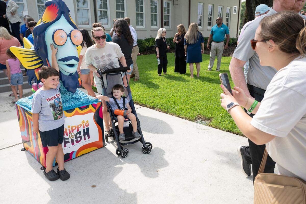 Visitors take photos during the grand opening of Hippie Fish at Centennial Plaza in Gulfport on Thursday, June 26, 2025.