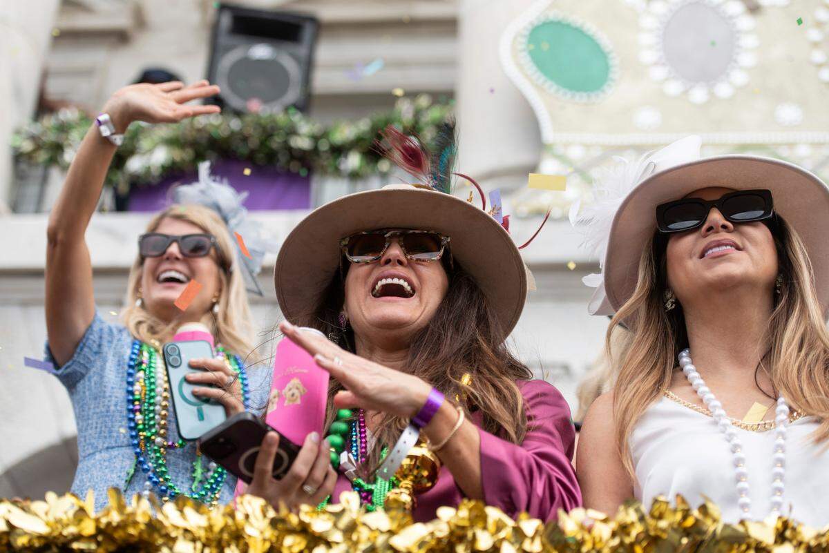 Parade watchers catch beads and other throws during the Gulf Coast Carnival Association Mardi Gras parade in Biloxi on Tuesday, March 4, 2025.