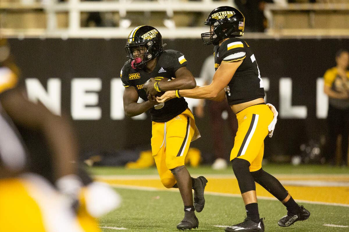 Southern Miss Golden Eagles quarterback Jake Lange (24) hands off a pass to Southern Miss Golden Eagles running back Frank Gore Jr. (3) during a game against Arkansas State at M.M. Roberts Stadium in Hattiesburg on Saturday, Oct. 15, 2022.