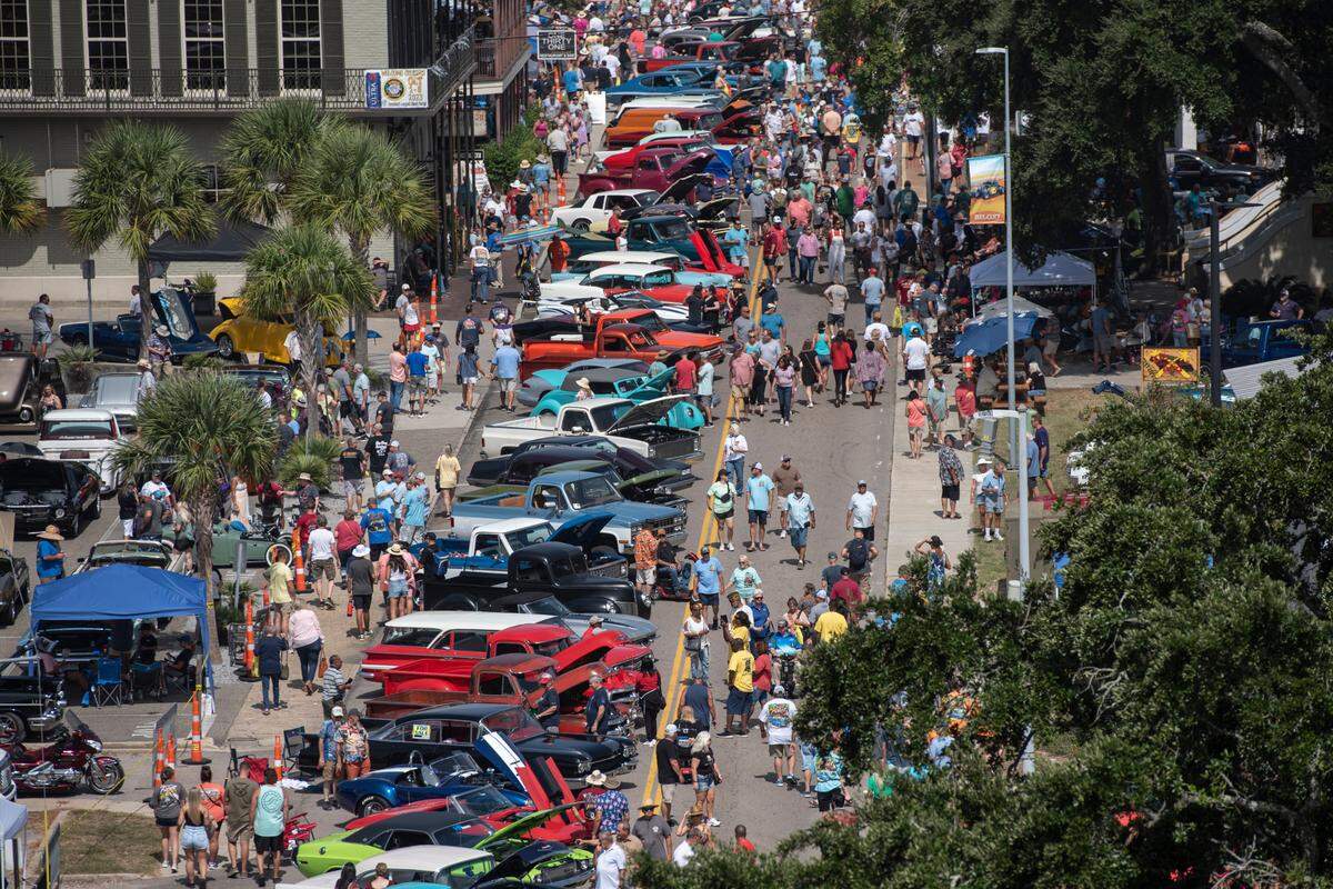 Spectators walk among classic cars in downtown during Biloxi Block Party during 2023 Cruising’ the Coast. The mix of sun, sand and cream puff cars creates Mississippi’s largest event.