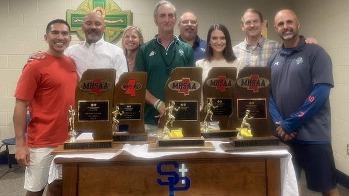 Stan Dellenger (middle) with his five state championship trophies.