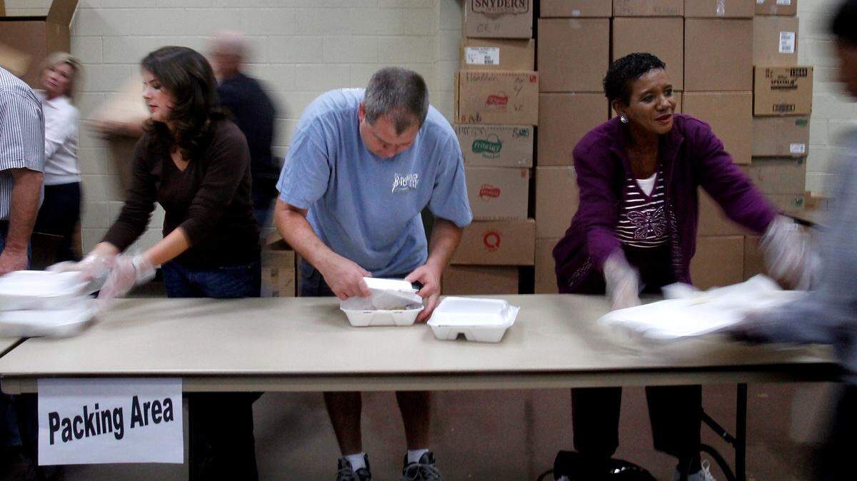 AMANDA McCOY/SUN HERALD/FILEVolunteers Erika Peterson, left, Bob Conover and Christine Brice package completed Thanksgiving dinners at the end of the assembly line during a previous Harrison County Feed the Needy.