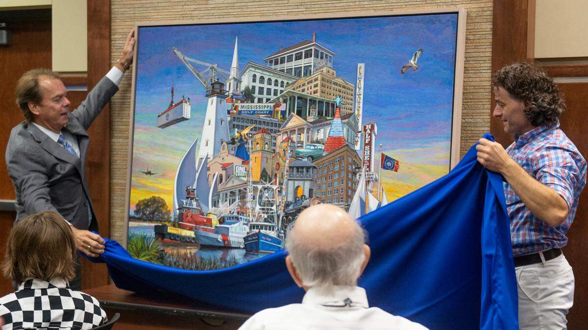 Gulfport Mayor Billy Hewes and artist Charles Buckley unveil a painting commissioned by Hewes for the 125th anniversary of the city of Gulfport at the Gulfport Police Department on Tuesday, July 18, 2023. The painting will be hung at city hall.