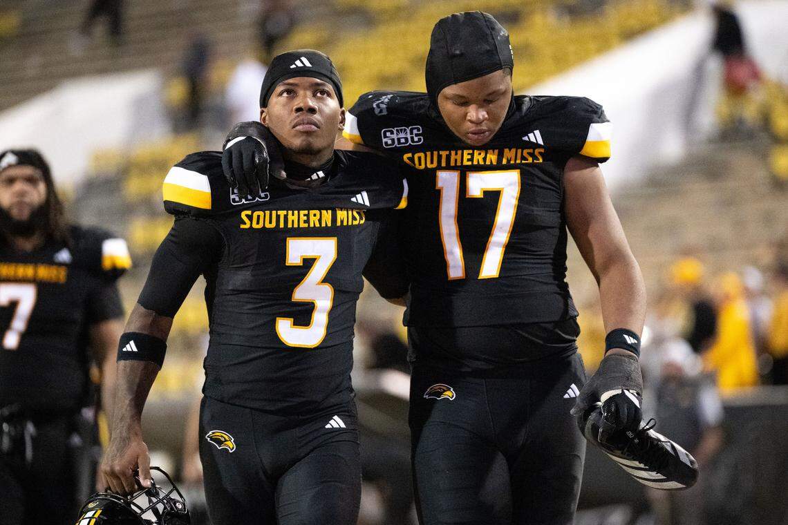 Southern Miss linebacker Michael Montgomery (17) and wide receiver Charles Montgomery (3) walk off the field after Saturday’s loss.