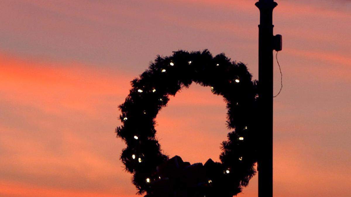 TIM ISBELL/SUN HERALD 
 The sky turns red just prior to sun rise at Jones Park in Gulfport, and along with the green wreath provides beautiful Christmas color in South Mississippi.