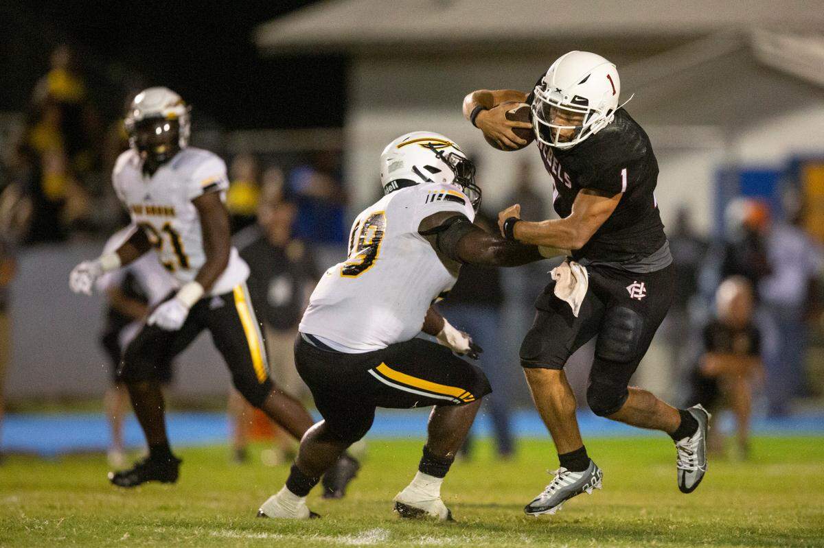 Harrison Central quarterback Christian Turner evades tackle during a game against Oak Grove at Milner Stadium in Gulfport on Friday, Aug. 26, 2022.