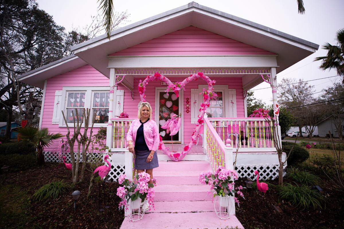 Alrie Poillion stands in front of her bright-pink house in Long Beach, Miss. donned with a week’s worth of Valentine’s Day decorations on Thursday, February 11, 2021 . Poillion, who has lived in Long Beach all her life, said she bought her home in 1998 and later painted it bright pink. She decorates for every holiday, but this year decided to “go all out” for Valentine’s Day after almost a year of the pandemic to spread a little love.