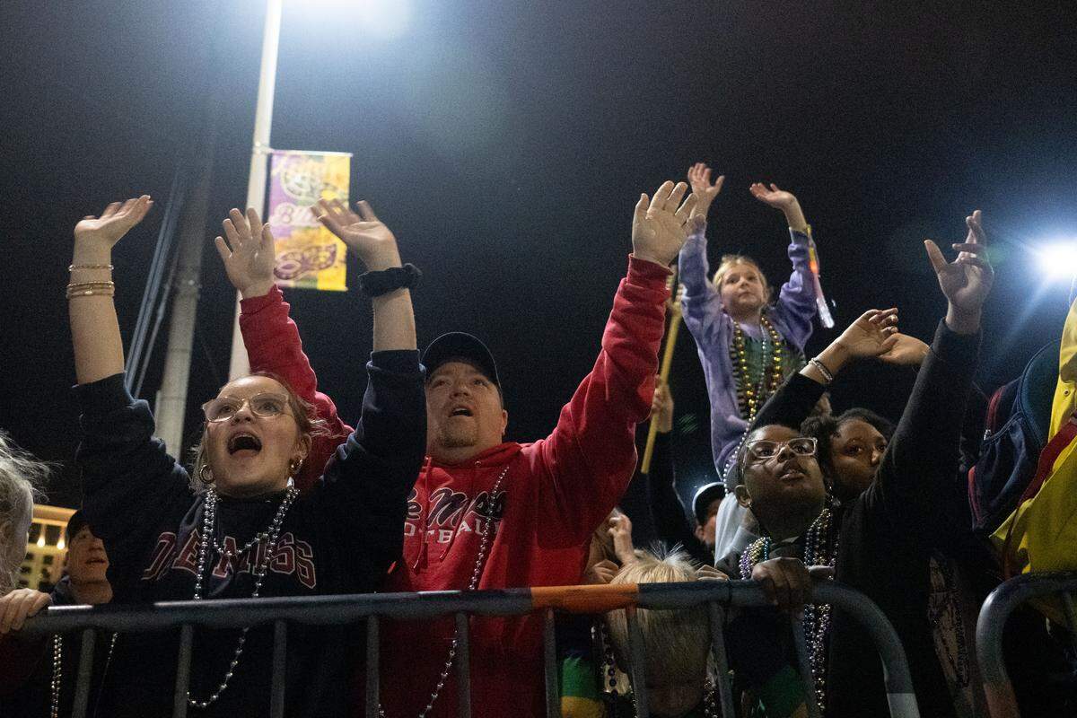 Parade attendees cheer as floats pass by during the Krewe of Neptune parade in Biloxi on Saturday, Feb. 14, 2026.