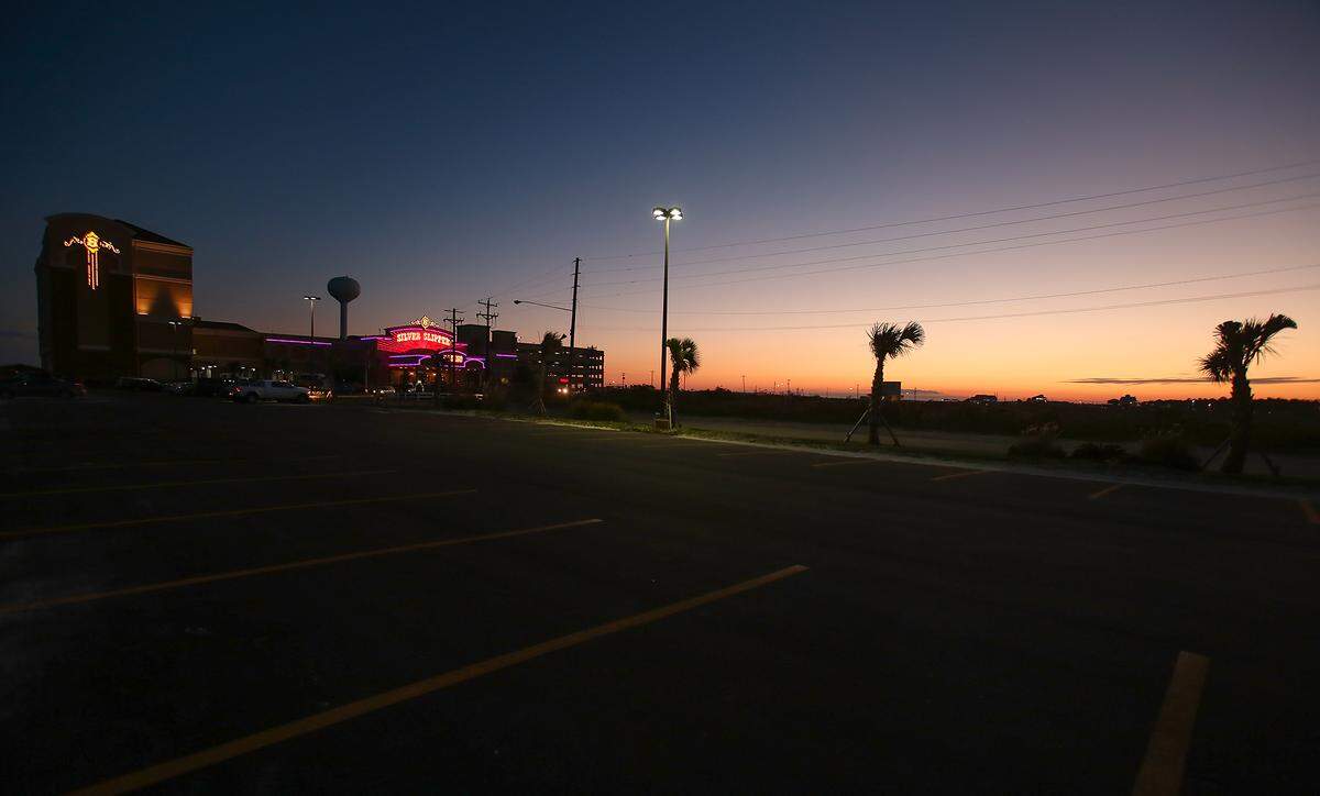 Silver Slipper Casino’s lights glow as the sun sets on the beach in Lakeshore. The landlords of Silver Slipper have site approval to build another casino just over a mile away on the Hancock County beach, and another developer will ask for site approval this week.