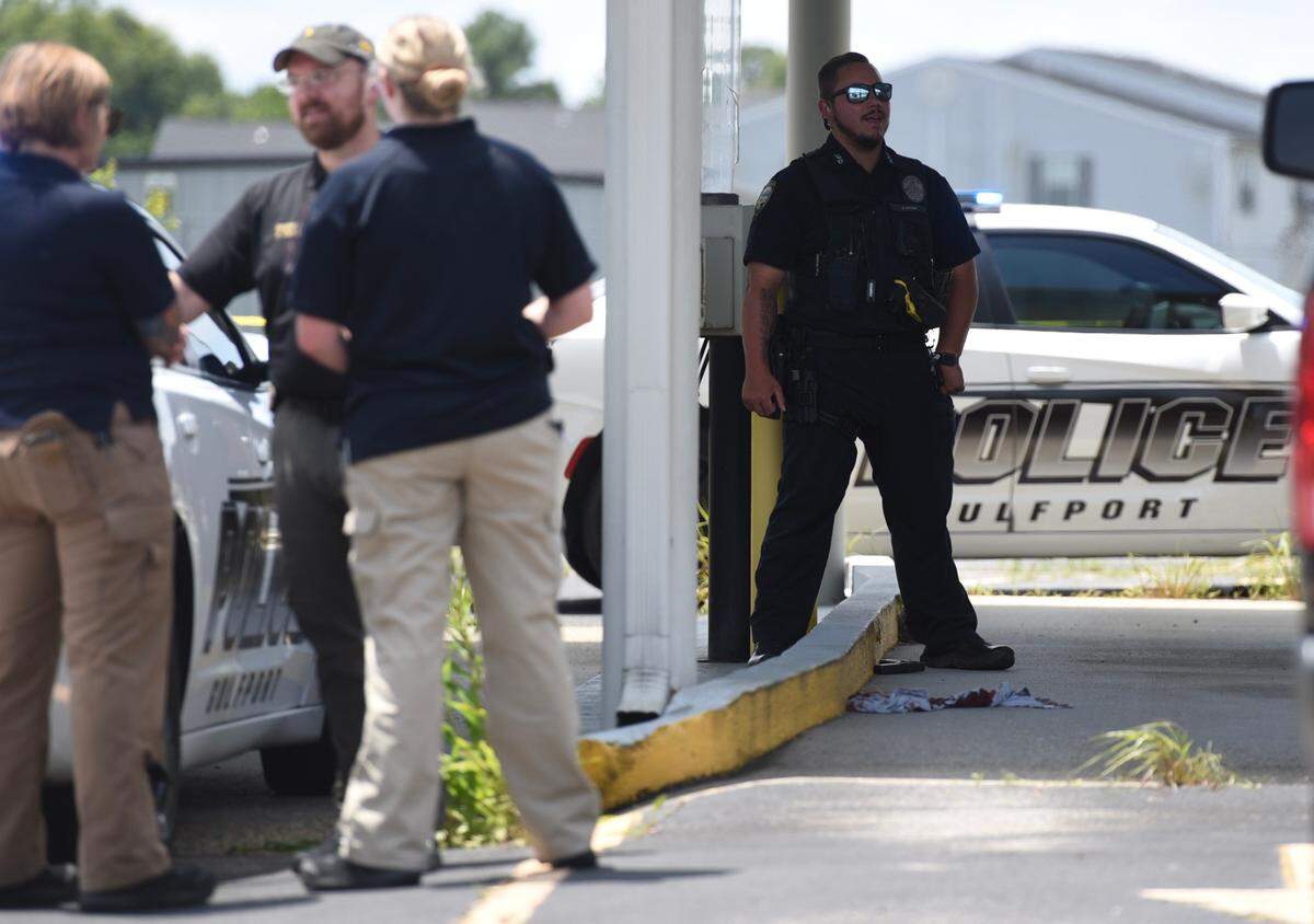 An officer stands near a gun on the ground at the scene of an officer-involved shooting in Gulfport Wednesday morning.