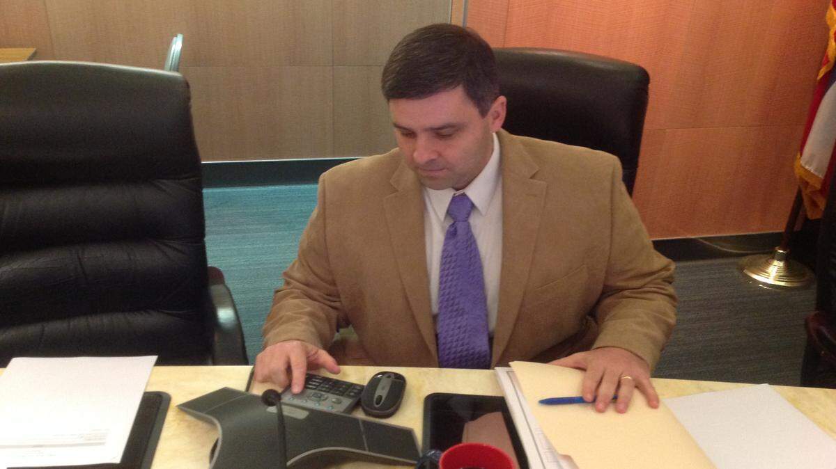 KAREN NELSON 
 
 Jackson County Supervisor Troy Ross, in his seat at the Board of Supervisors' table in the County Services Complex, looks over the equipment he will use to participate in the April board meeting via telephone from Fort Bragg, N.C.