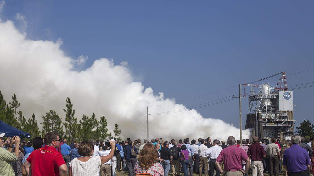 AMANDA McCOY/SUN HERALD/FILE 
 Spectators gather for the RS-25 Engine Test at Stennis Space Center on Aug. 13. Hundreds of people who work at Stennis are reapplying for their jobs after a new contract to operate and maintain the facility will consolidate services with Michoud Assembly Facility in New Orleans to save money.