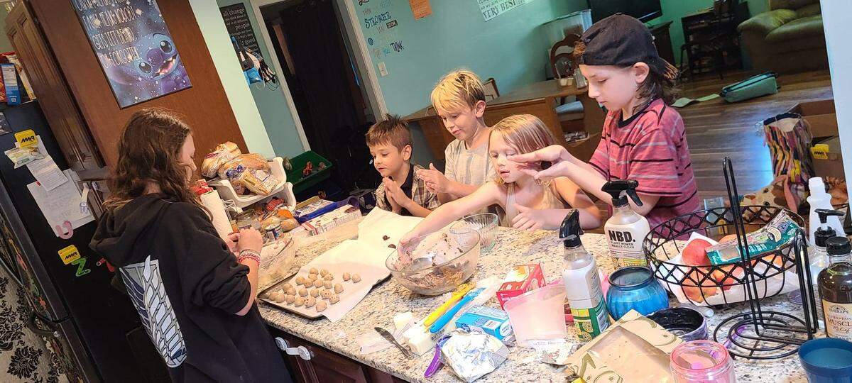 Some of Bev Bisbee’s children prepare no-bake cookie balls in July 2020. They’ll return to the kitchen to help Bisbee bake Thanksgiving pies.