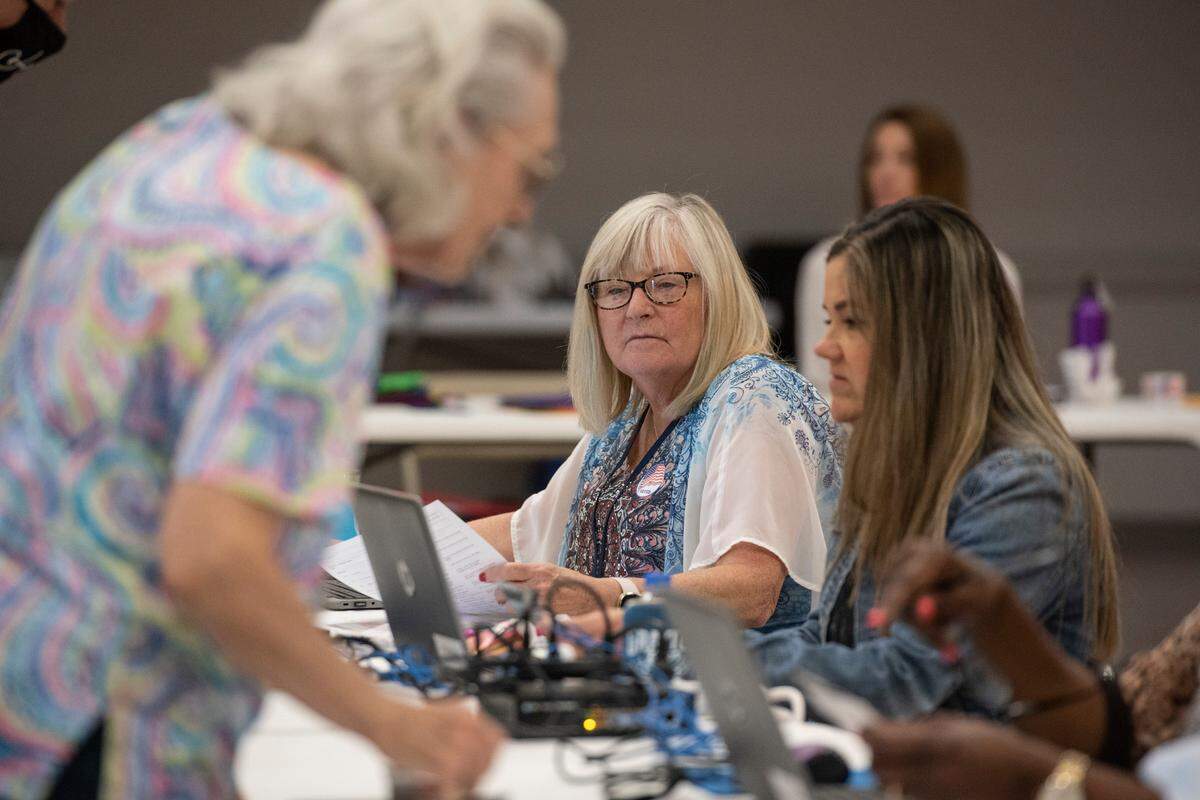 Election workers check in voters as they arrive to vote in the Mississippi primary election at the D’Iberville Civic Center in D’Iberville on Tuesday, June 7, 2022.