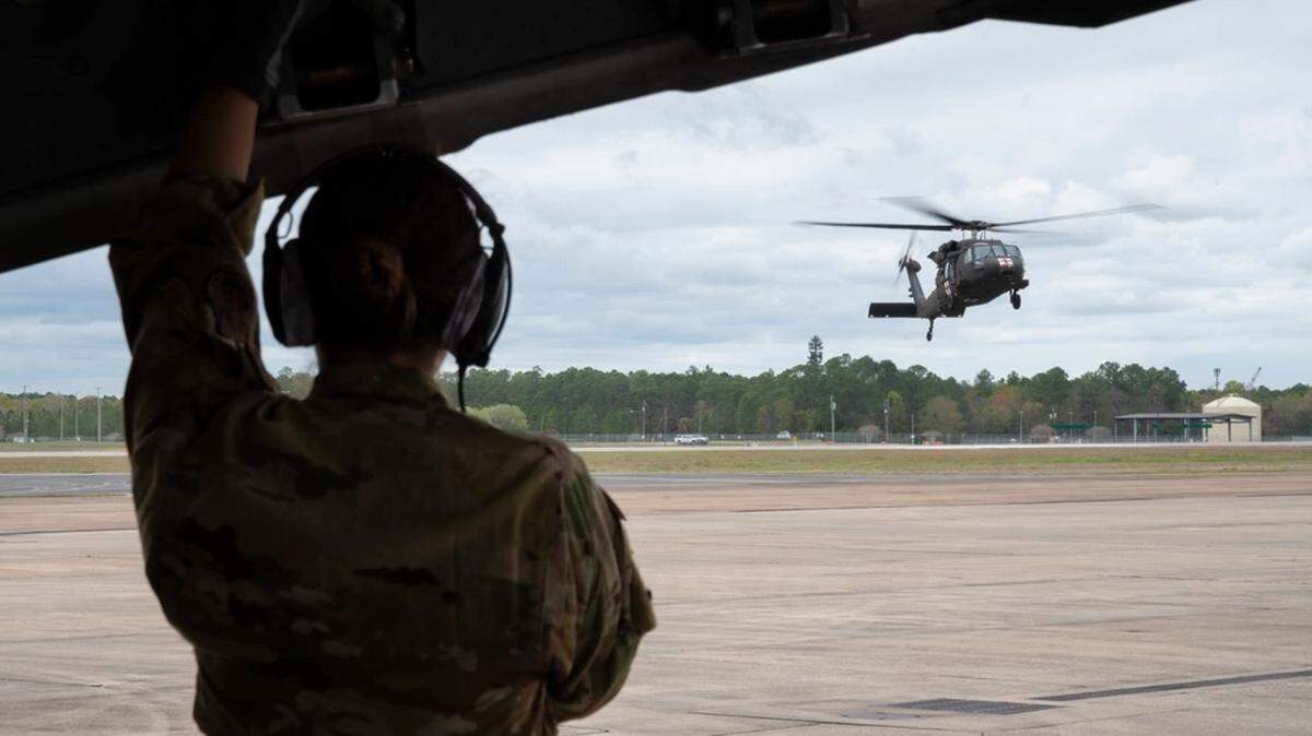 A U.S. Army UH-60 Black Hawk helicopter, assigned to the 3rd Battalion, 238th Aviation Regiment General Support Aviation Battalion, Michigan Army National Guard, lands beside a U.S. Air Force C-130 Hercules aircraft, assigned to the 186th Air Refueling Wing, Mississippi Air National Guard, in preparation for combat air medical operations training during Southern Strike 2024 at Gulfport Combat Readiness Training Center, in Gulfport, Mississippi, March 13, 2024.