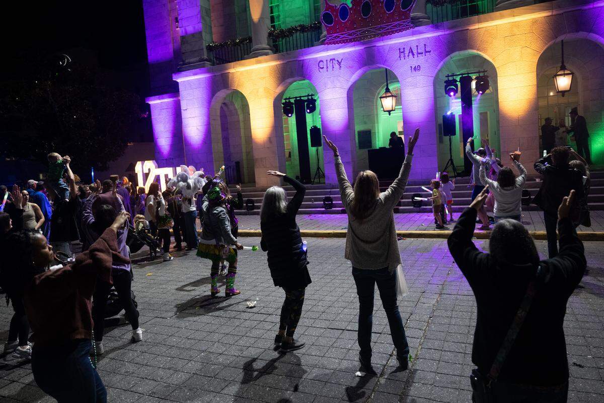 Event attendees dance in front of Biloxi City Hall during a 12th Night Celebration in Biloxi on Monday, Jan. 5, 2026.