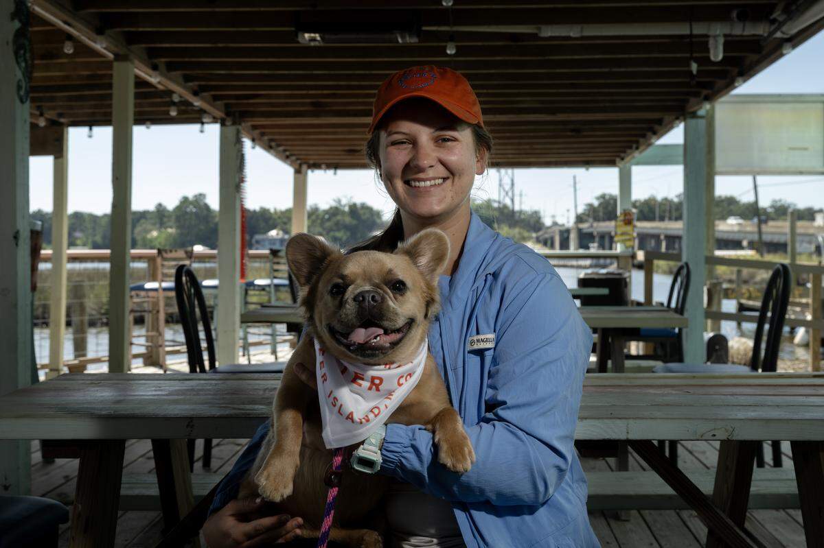 Ryleigh Sprague, a marine biologist and manager at French Hermit Oyster Co., poses for a portrait with Nina, a French bulldog.