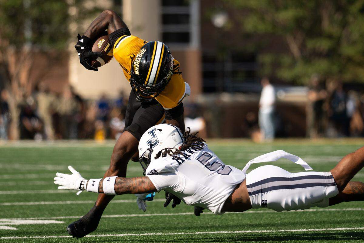 Southern Miss wide receiver Bralon Brown (8) evades a tackle by Jackson State defensive back Shamar Hawkins (5) .