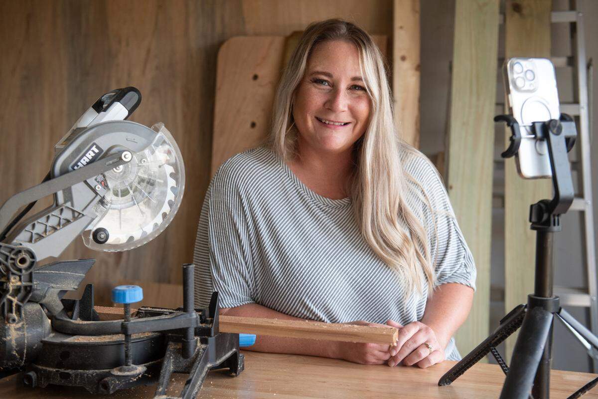 Sarah Blackbourn poses for a photo in her garage, where she does her woodworking projects, at her home on Monday, July 22, 2024. Blackbourn started using social media to promote her woodworking business and eventually started using it to document raising chickens.