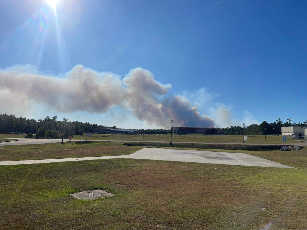 Smoke, seen from Highway 67 near the Mississippi Department of Public Safety, rose in the distance as crews fought a woods fire on Wednesday in Harrison County.