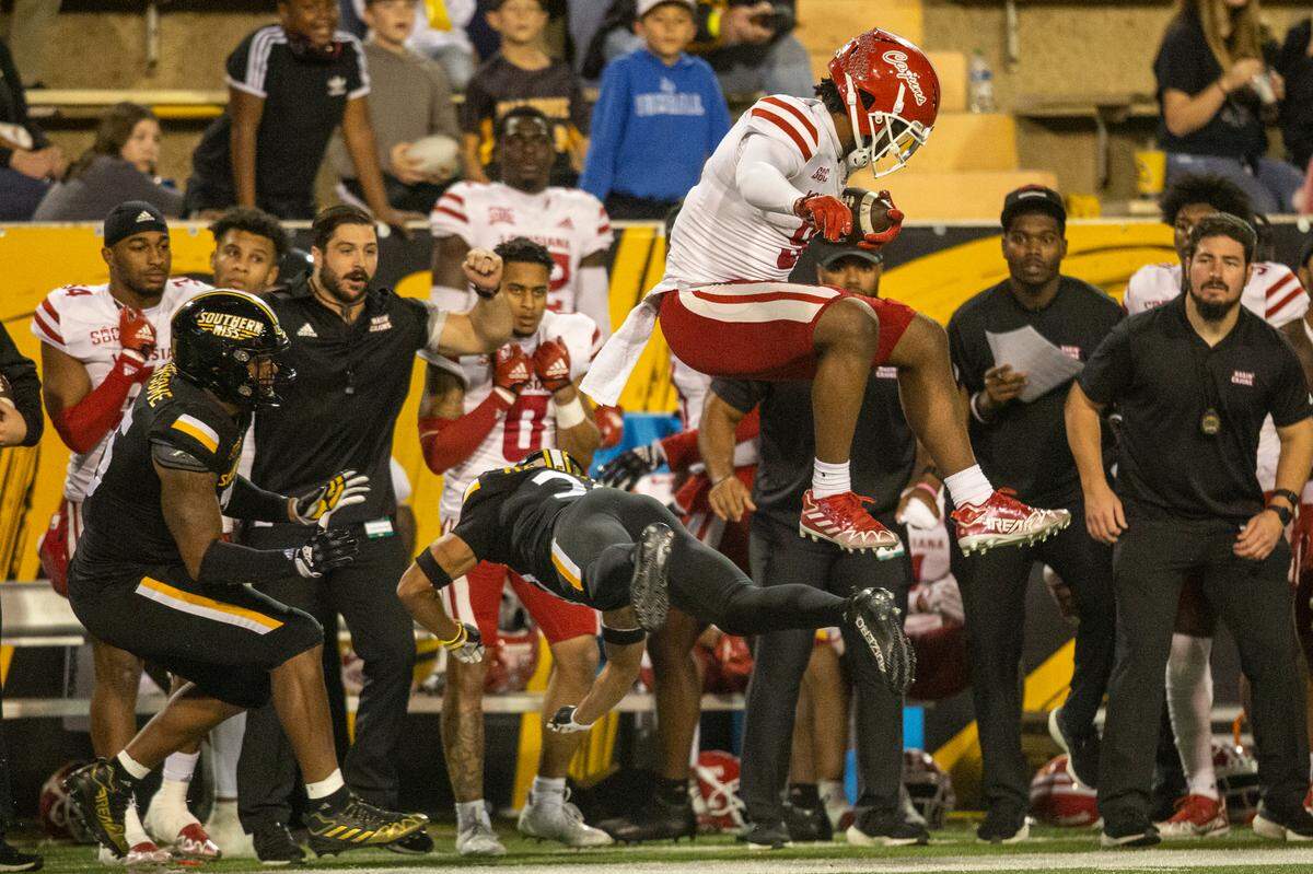 Louisiana-Lafayette tight end Neal Johnson Jr. (9) jumps over Southern Miss’ defense as he runs the ball during the second half of an NCAA college football game in Hattiesburg, Miss., Thursday, Oct. 27, 2022. (Hannah Ruhoff/The Sun Herald via AP)