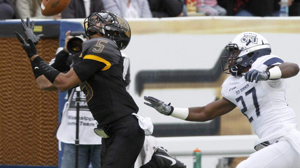 TIM ISBELL/SUN HERALD 
 Southern Miss receiver D. J. Thompson tries to catch a Nick Mullens pass as Old Dominion cornerback Aaron Young trails, Saturday, Nov. 21, 2015. Thompson dropped the pass.