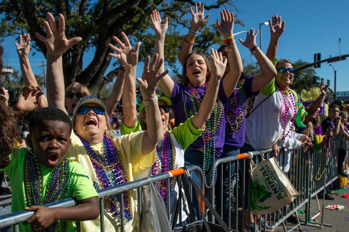 Crowds cheer for beads during the Gulf Coast Carnival Association Mardi Gras Parade in Biloxi on Tuesday, March 1, 2022.