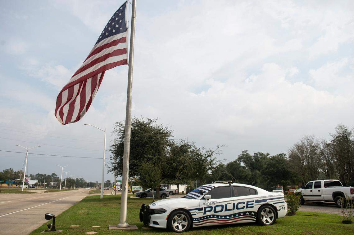 A police car with a thin blue line flag sits outside the Bay St. Louis Police Station in honor of officers Steven Robin and Brandon Estorffe who were killed in the line of duty on Wednesday, Dec. 14, 2022.