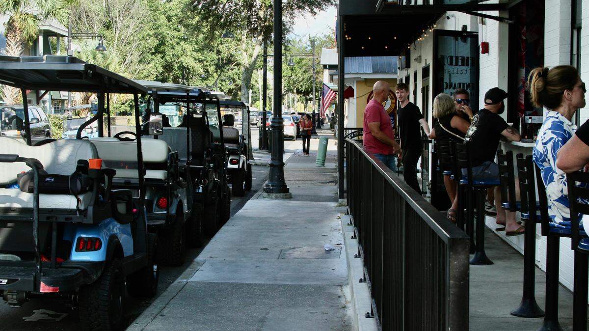 Golf cart parking has been added in several locations on Government Street in downtown Ocean Springs to make more room for traffic on the busy street, including in front of Field’s Italian Ocean Springs, where patrons enjoy the street-side bar.