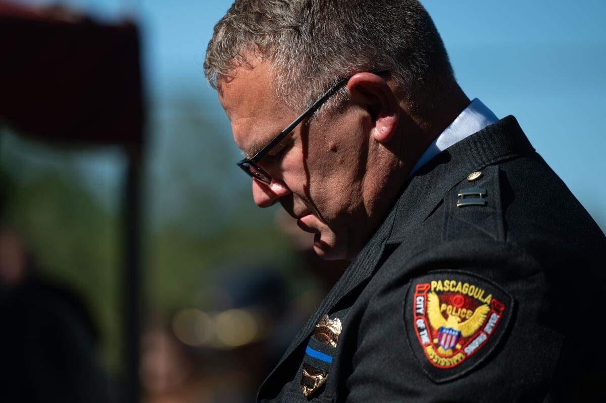 A member the Pascagoula Police Department lowers his head Wednesday during the funeral for Joshua Brashears.
