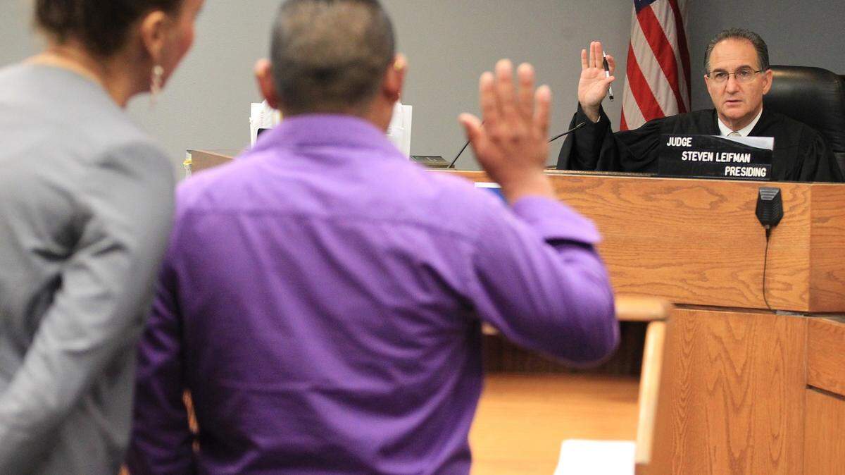 Judge Steve Leifman, right, swears-in a defendant during traffic court inside Richard E. Gerstein Justice Building on May 12, 2016 in Miami, Fla. Leifman created the Criminal Mental Health Program about 10 years ago, and the New England Journal of Medicine has held it up as a model for other large cities struggling with the revolving door of mentally ill people cycling through criminal justice systems, which is costly and doesn't prevent crime or rehabilitate the mentally ill. (Carl Juste/Miami Herald/TNS)
