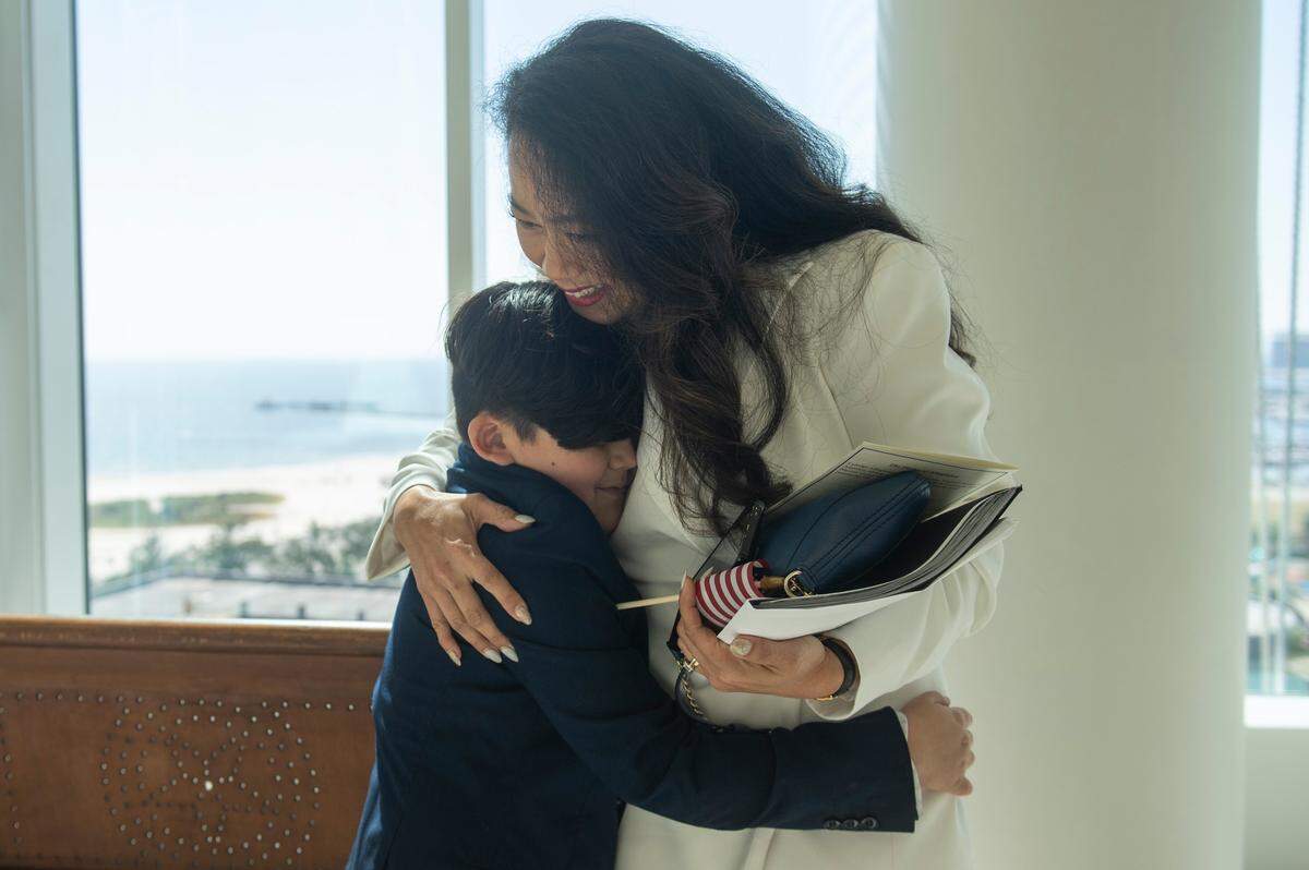 A woman hugs her son after becoming a naturalized American citizen during a naturalization ceremony at Dan M. Russell Jr. Federal Courthouse in Gulfport on Friday, Oct. 7, 2022.