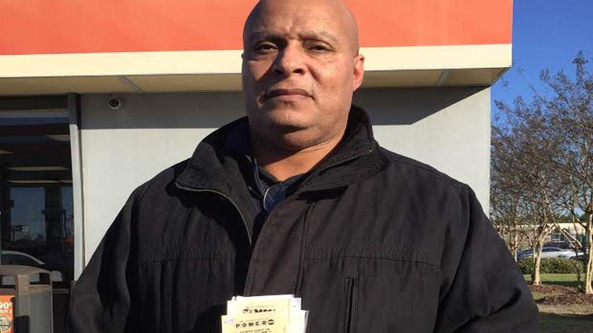 JEFF CLARK/SUN HERALD 
 Alfonzo Walker of Biloxi shows off his fistful of Louisiana Lottery Powerball tickets he purchased in Slidell Tuesday morning.
