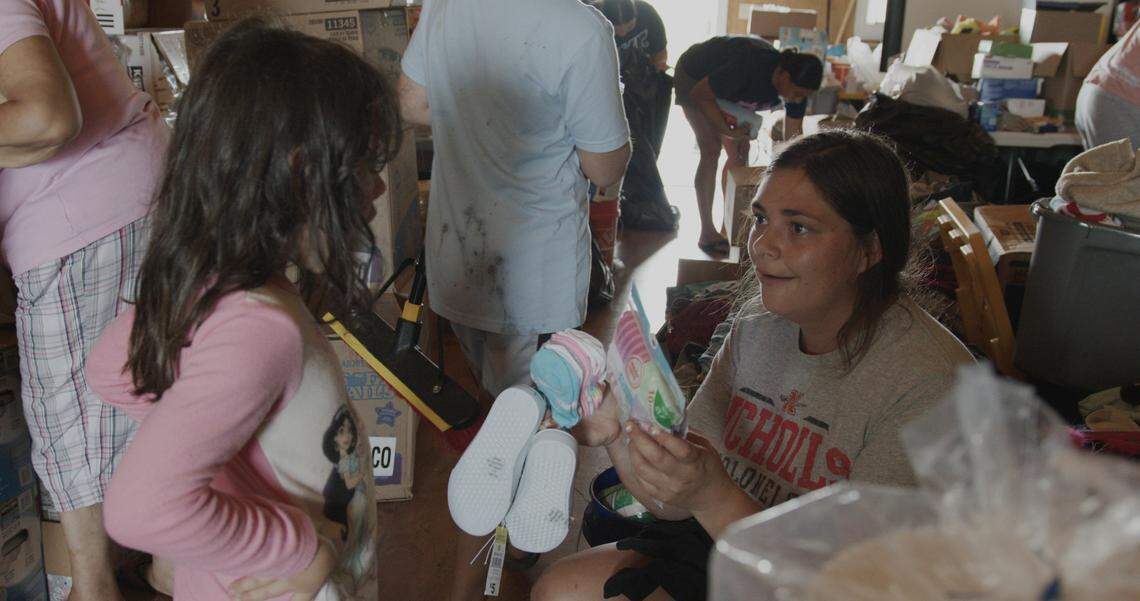 Samantha Boudreaux picks out socks and shoes for her daughter Pointe-au-Chien tribal center in September 2021. Since Hurricane Ida, the center has become a source of free food, clothing, and household supplies for the community.