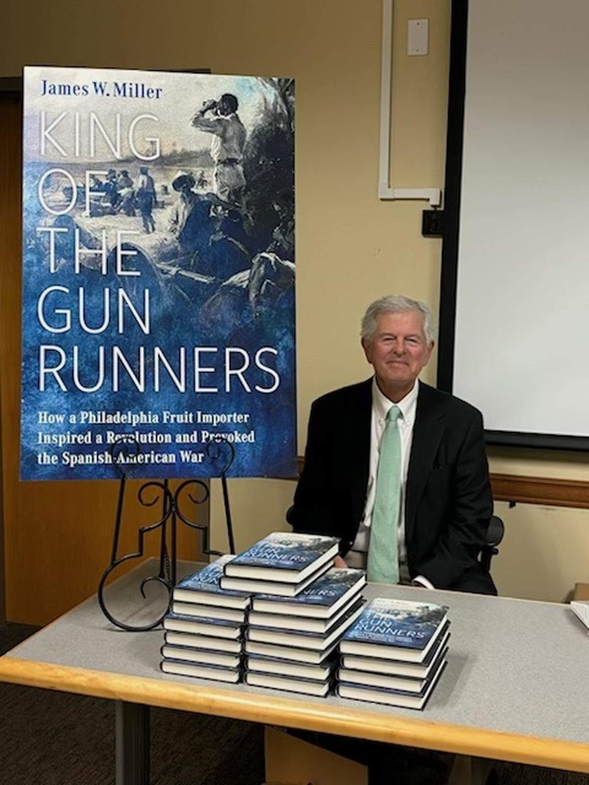 Author Jim Miller sits at a book signing.