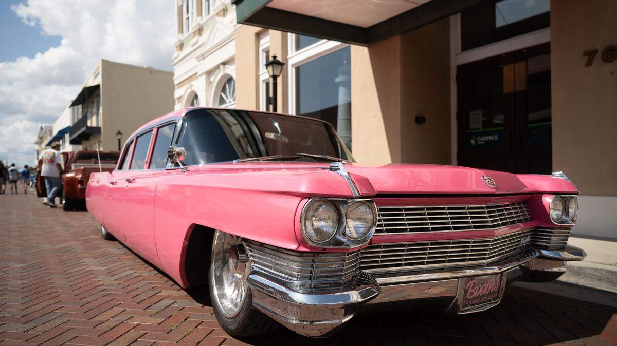 Event attendees check out cars parked in Downtown Biloxi during the Biloxi Block Party on Wednesday, Oct. 8, 2025.